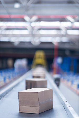 View of modern conveyor belts transporting boxes in a large warehouse ready for deliveryの写真素材