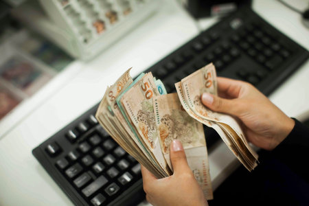 Human hand of businessman working in exchange office/bank. He is counting money and giving cash...