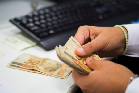Human hand of businessman working in exchange office/bank. He is counting money and giving cash...