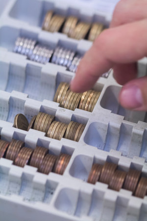 Human hand of businessman working in exchange office/bank. He is counting money and giving cash money to a customer. Coins.の写真素材