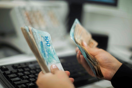Human hand of businessman working in exchange office/bank. He is counting money and giving cash...