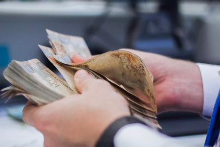 Human hand of businessman working in exchange office/bank. He is counting money and giving cash...