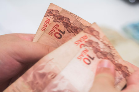 Human hand of businessman working in exchange office/bank. He is counting money and giving cash...