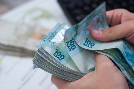 Human hand of businessman working in exchange office/bank. He is counting money and giving cash...