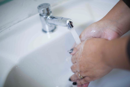 Close up of human hand washing hand on sink.の写真素材