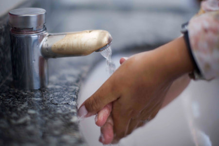 Close up of human hand washing hand on sink.の写真素材