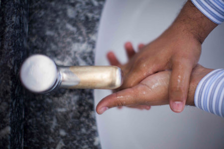 Close up of human hand washing hand on sink.の写真素材