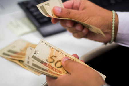Human hand of businessman working in exchange office/bank. He is counting money and giving cash...