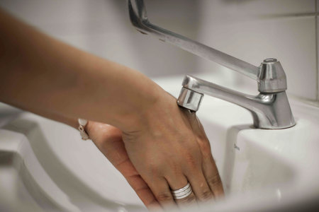 Close up of human hand washing hand on sink.の写真素材