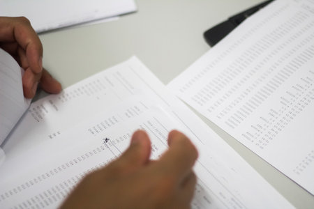 Crop shot of a business person with pen signing document / contract at desk in daylight.の写真素材