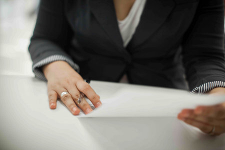 Crop shot of a business person with pen signing document / contract at desk in daylight.の写真素材