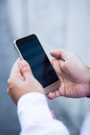Hand of business people holding smartphone - mobile phone.