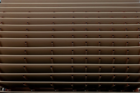 Large stacks of wood panels or MDF sheets arranged inside an industrial production facility. The image shows part of the machinery used to process and dry wood panels.の写真素材