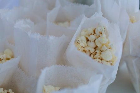 Several paper cones filled with popcorn arranged together. The image shows a snack setup suitable for parties, events, or food service.の写真素材