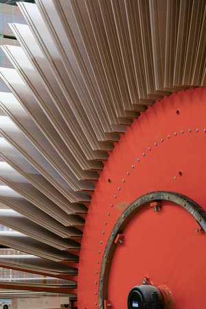 Large stacks of wood panels or MDF sheets arranged inside an industrial production facility. The...