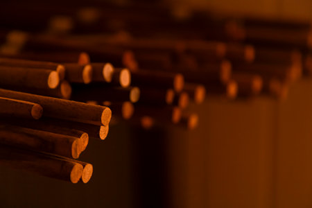 Thin wooden sticks organized on a workbench for handcrafted production.