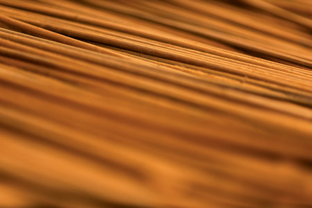 Thin wooden sticks organized on a workbench for handcrafted production.の写真素材
