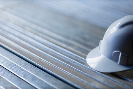White safety helmet on metal surface construction concept