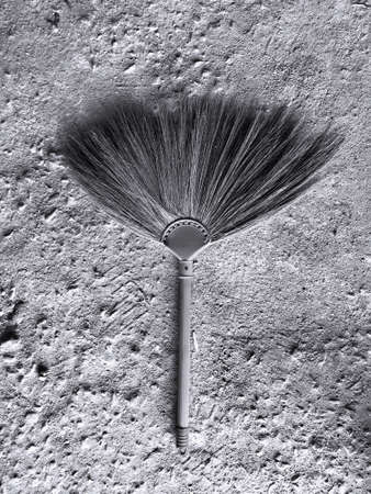 The broom that was laid on the cement floor was made into gray tones.の写真素材