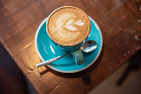 Hot Coffee Latte Art on the Wooden Tableの写真素材