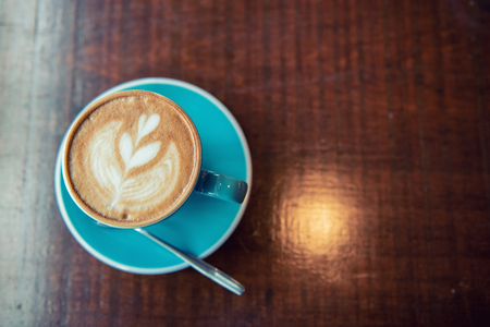 Hot Coffee Latte Art on the Wooden Tableの写真素材
