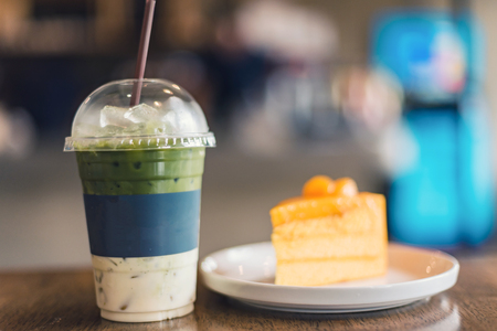 Orange cake and iced matcha green tea latte with milkの写真素材