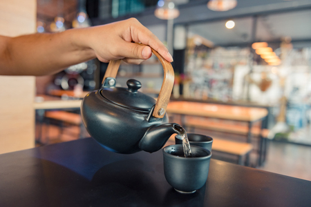 Kettle pouring boiling water into a cup during coffee time in coffee shopの写真素材