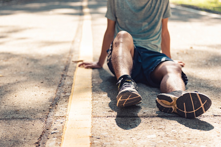 Young man runner resting after workout on sunny morning.
