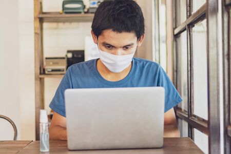 The man wear a mask to protect against the Coronavirus Covid-19, work  from homeの写真素材