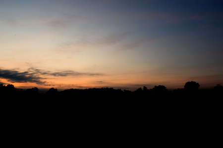 The sun rises in the morning sky with cloudsの写真素材