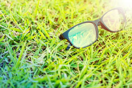 Glasses lay on the grass in the sunshine in evening time.の写真素材