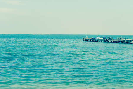 Fishing pier jutting into the blue sea and sky.の写真素材