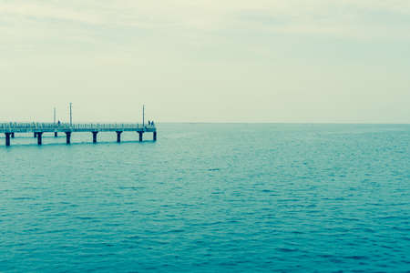 Fishing pier jutting into the blue sea and clear sky.の写真素材