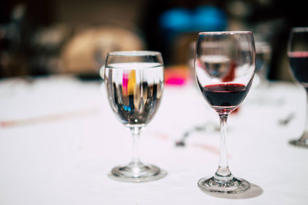 Glass of red wine and a glass of water on the table in party.の写真素材