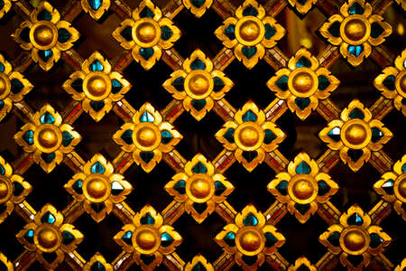 Work on the temple wall carvings of Thailand in golden tone.の写真素材
