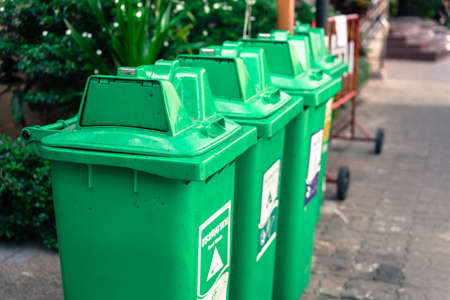 Green bins lined the park in sun light.の写真素材