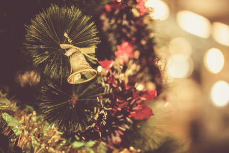 Gold bell on the Christmas tree in the new year in vintage warm tone.