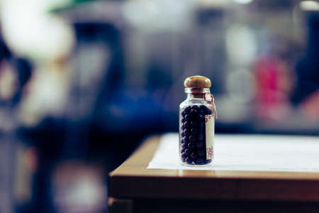 Lozenge bottle on the table in a room with low light in soft light.の写真素材