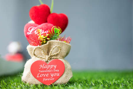 Heart-shaped Valentine's Day gifts in a sack on the grass outside terrace at morning.の写真素材