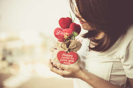 Heart-shaped gift in sack Place the hands on the girl on the balcony in vintage tone.の写真素材