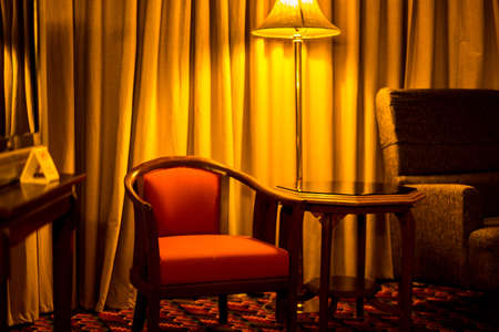 Light yellow and red chair in the bedroom at night.の写真素材