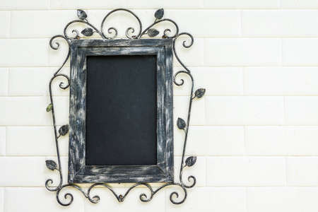 Antique picture frame hanging on a white wall in sunshine.の写真素材