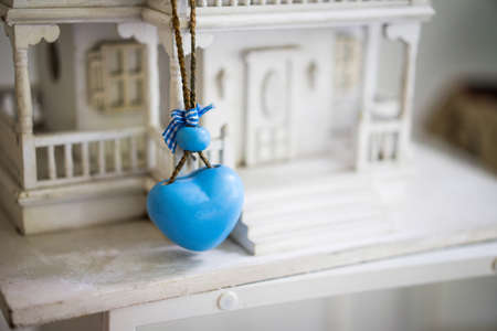 Blue Heart hung on a model home in white colour.の写真素材