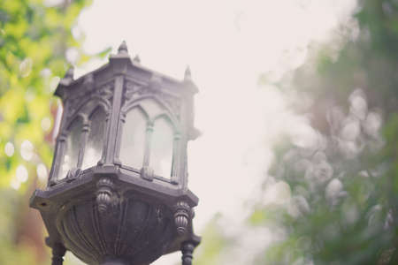 Old black lantern in a park in the sunshine day.の写真素材