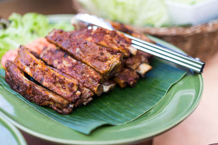 Grilled pork steak placed on banana leaves in dinner.の写真素材