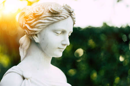 Statue of a girl in a garden in the sunshine.の写真素材