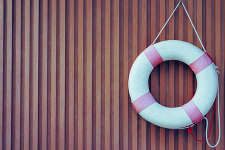 Suspension ring hanging on a wooden wall in old tone.の写真素材