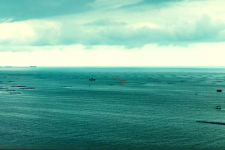 The sea and fishing boats on a cloudy day in rain.の写真素材