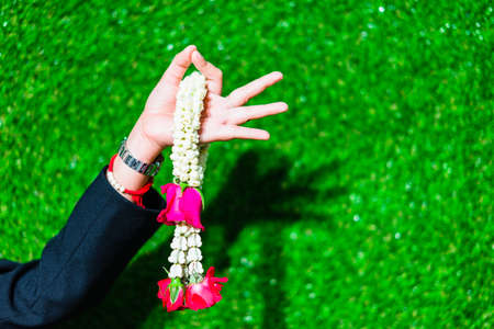 Young woman holding a wreath on a green grass background.