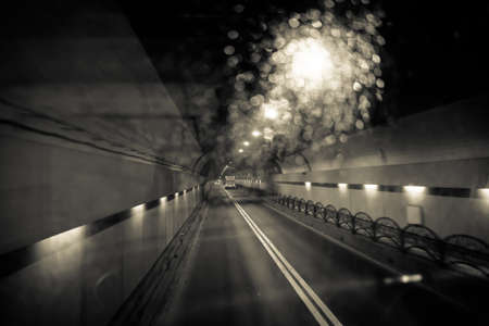 Dark tunnel car at night, traveling on target in black and white tone.